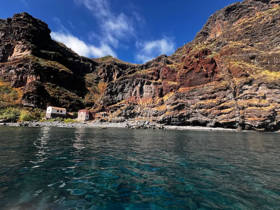 Calhau da Lapa, with its small houses at the foot of the cliffs, seen from the sea
