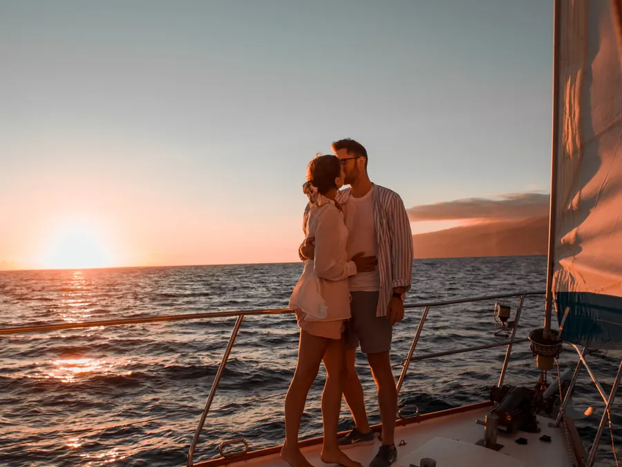 A couple embracing on the foredeck at sunset