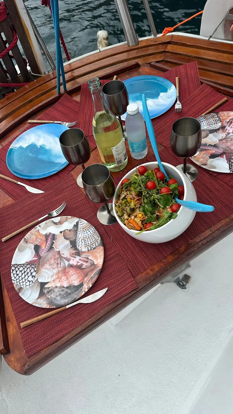 Salad, plates and wine set out for lunch on board
