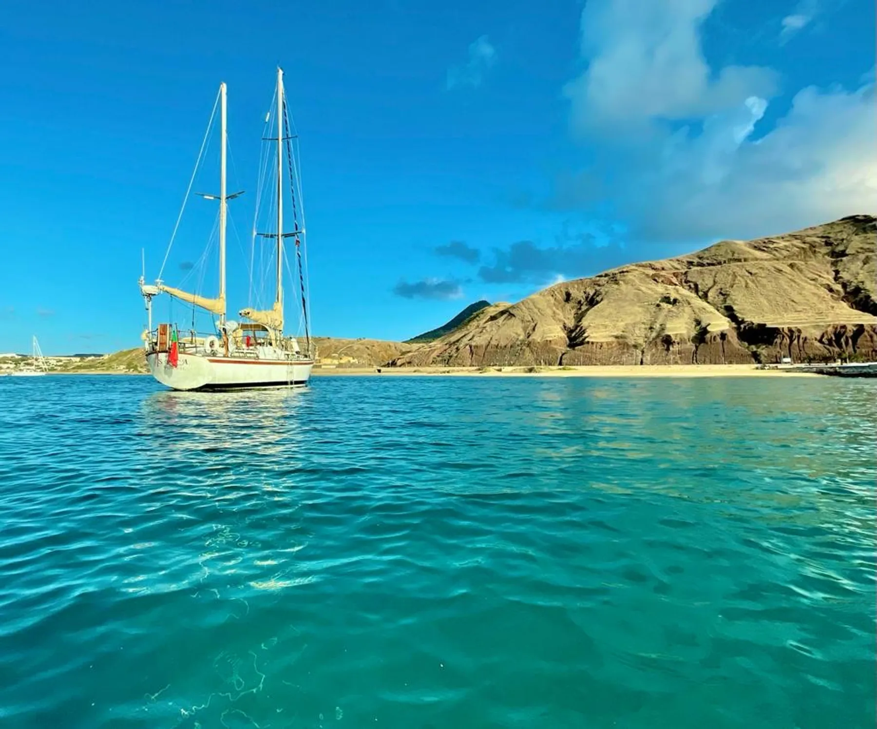 Spica at anchor in turquoise water off Porto Santo