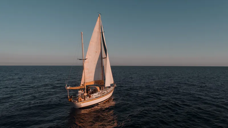 Spica Yacht under sail at sunset, seen from above off the coast of Madeira