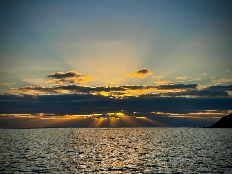 The sun setting behind clouds over the Atlantic